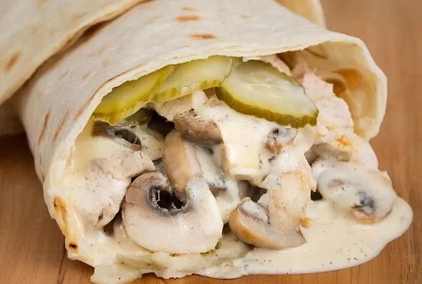 Первый тост — и рулета уже нет. Это блюдо из лаваша с куриным филе, грибами и соленым огурцом. Вкус знакомый, но форма — беспроигрышная