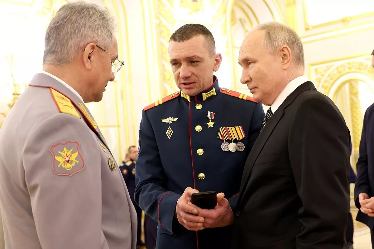 Герой России младший сержант Николай Харченко с президентом РФ Владимиром Путиным и министром обороны Сергеем Шойгу на торжественном мероприятии по случаю празднования Дня Героев Отечества. 