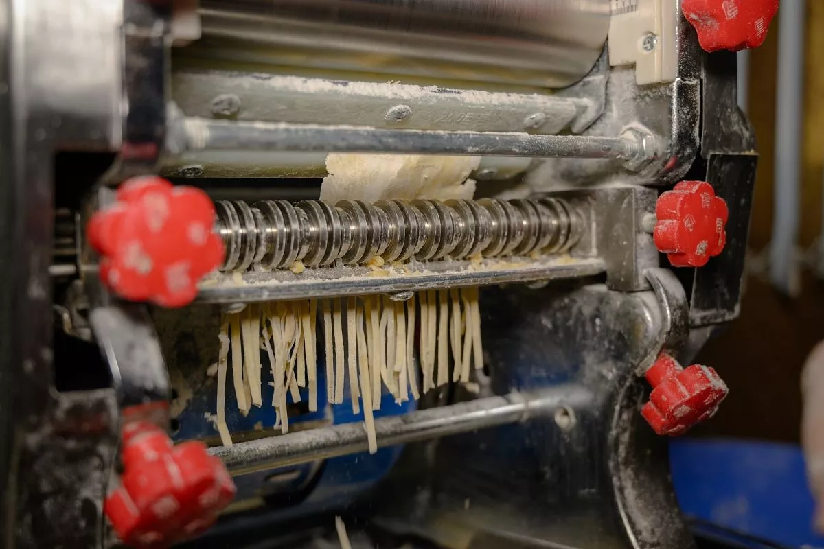 Работу по нарезке лапши облегчает специальная машина , которую волонтерам подарили благотворители.