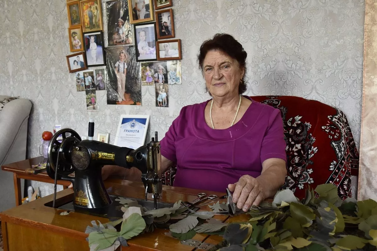 Валентина Прядкина получила от волонтеров вырезанные лепестки из ткани для маскировки, теперь нашивает их на штаны.