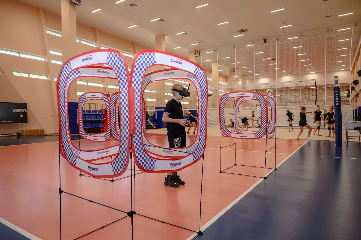 Одним из этапов состязаний на гонках дронов является прохождение воздушных трасс в помещении.