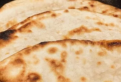 Кефир, яйцо и мука — и через десять минут на столе уже ароматные, мягкие лепешки с тягучим сыром и свежей зеленью. На аромат собираются все домочадцы 