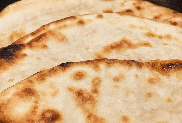 Кефир, яйцо и мука — и через десять минут на столе уже ароматные, мягкие лепешки с тягучим сыром и свежей зеленью. На аромат собираются все домочадцы 