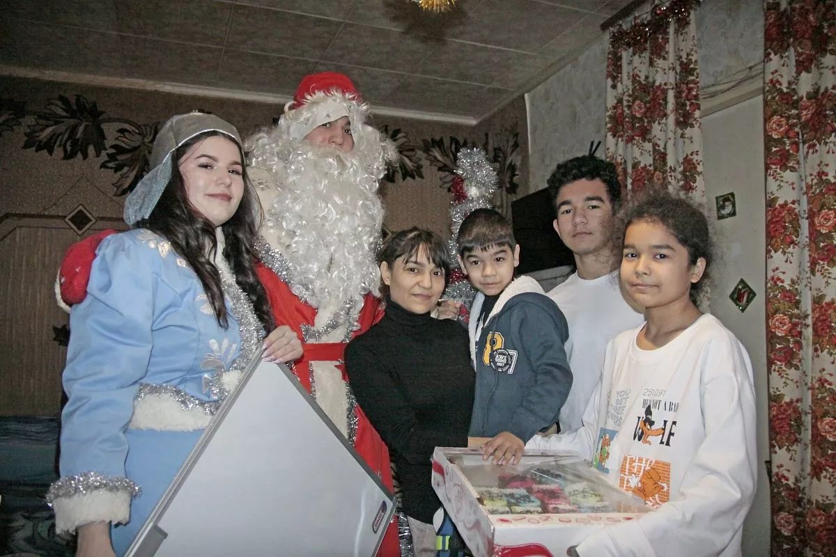 Магнитную доску для домашнего обучения от «Кубанских новостей» Дамиру вручили участники новогоднего шествия Артем Гибиленко и Оксана Шишкина.   