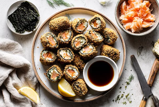 Разбиваю остатки лосося в тонкий пласт, рублю кубиком и заворачиваю в нори с сыром — жарю в сухарях и получаю хрустящие рулетики