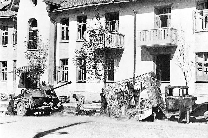 Расчет немецкой зенитной пушки прикрывает объект. Рядом с установкой разбитый советский грузовой автомобиль.