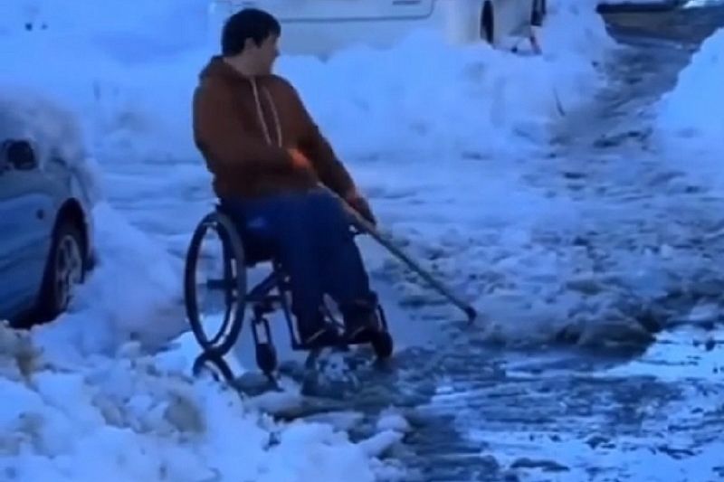 Мужчина на инвалидной коляске расчищал двор от снега в Краснодаре
