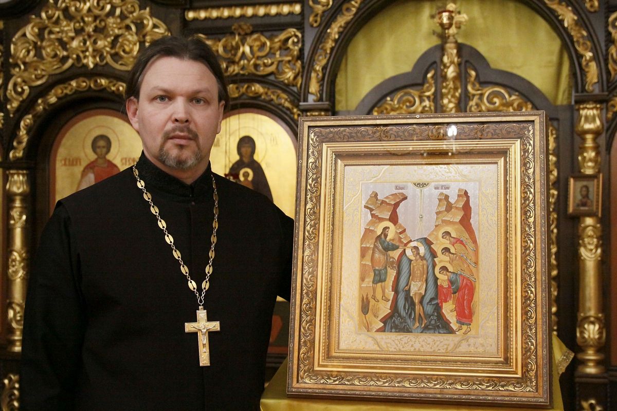 Священник Михаил Острожинский с иконой Богоявления в руках.