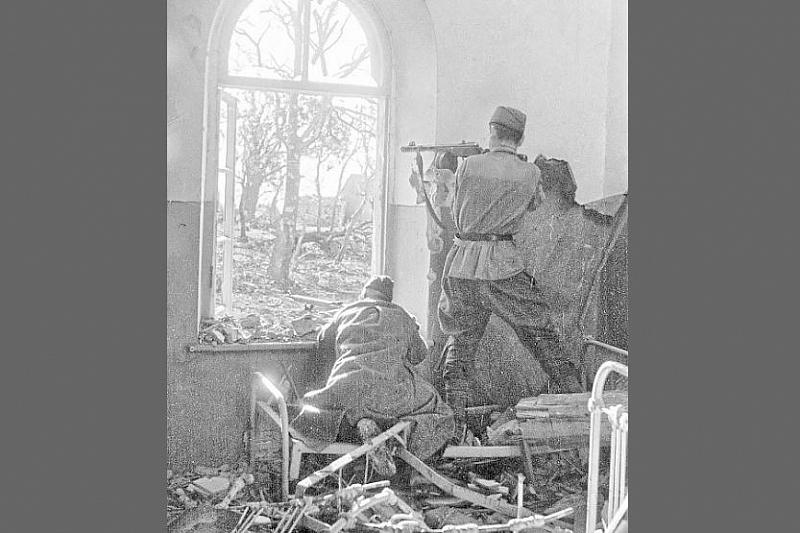 Советские бойцы ведут огонь из оконного проема в доме на окраине Новороссийска.