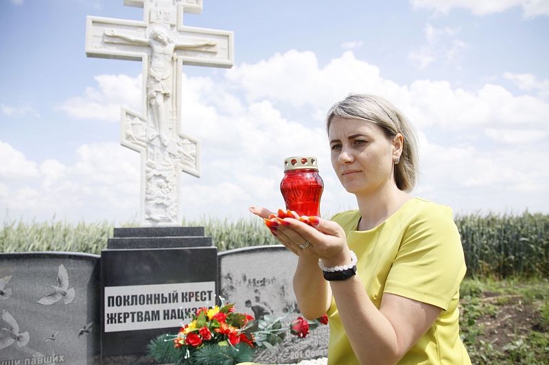 Лидер молодогвардейского движения Ильинского сельского поселения Наталья Кулинич со свечой памяти возле недавно открытого памятника на месте массового расстрела нацистами мирных граждан. 