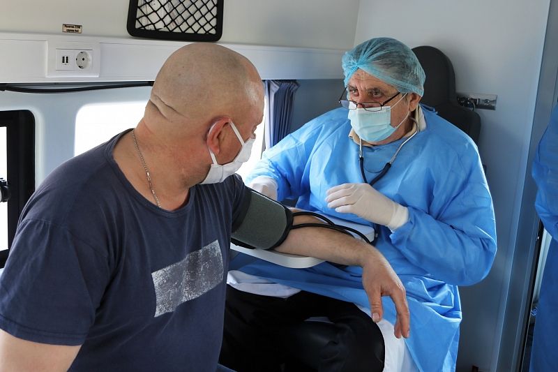Врач Виктор Погосян проводит медосмотр перед прививкой в мобильном пункте вакцинации Тихорецкой районной поликлиники.