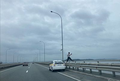 Во Владивостоке таксист забрался на бордюр моста ради красивого кадра моря