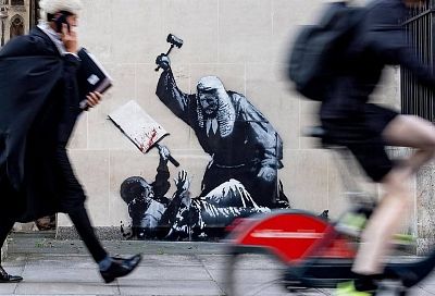 Судья, избивающий молотком протестующего, появился на стене в Лондоне